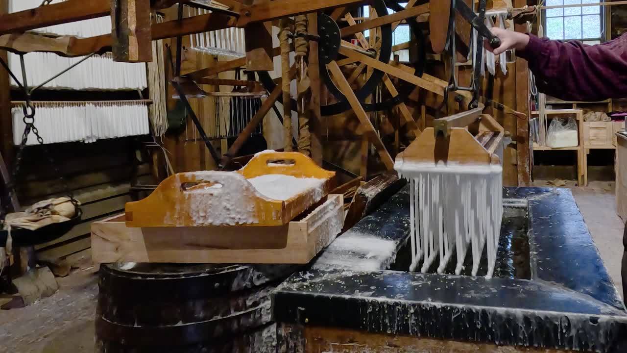 Hand-dipping candles in wax at Ballarat workshop