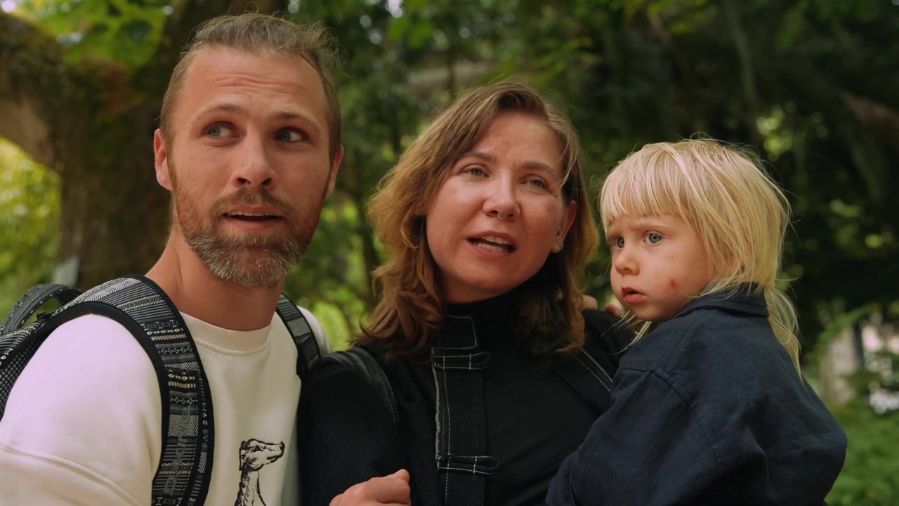 Junge Familie mit Kind im Gespräch in der Natur