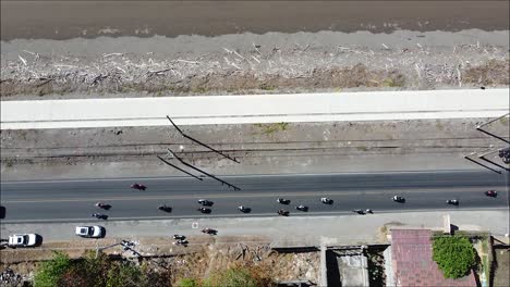 many-motorcycles-and-car-on-the-road-by-the-sea,-costa-rica,-puntarenas,-pura-vida,-long-street,-beach