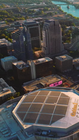 flying over modern beautiful sacramento in california state on sunny day. river with bridges over it at backdrop. top view. vertical video