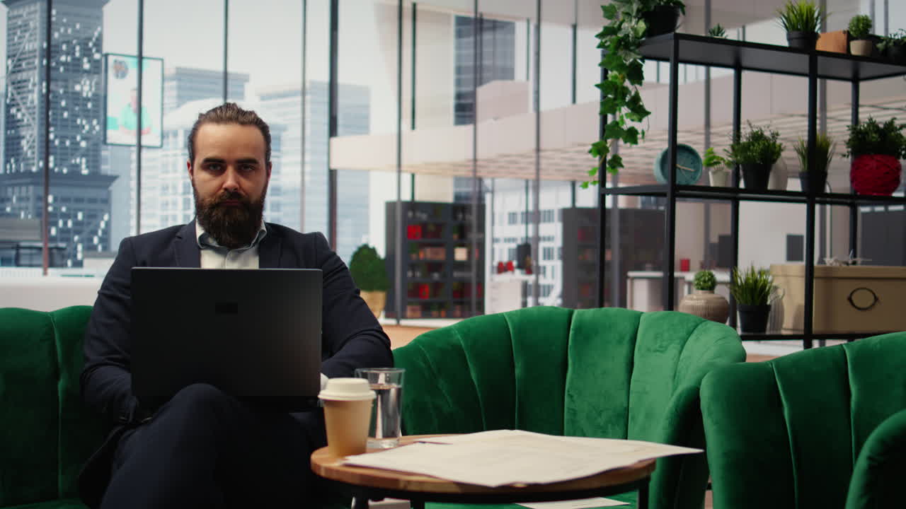 Determined CEO working on laptop in his modern office to create an analysis