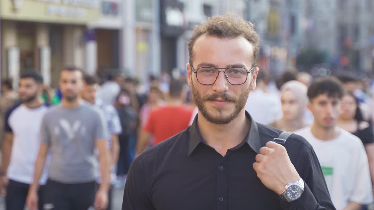 un joven riendo en la multitud.