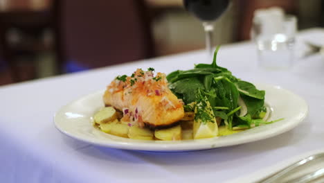 salmon steak with baked potatoes and salad