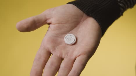 primer plano de la mano que sostiene el caramelo del corazón con el mensaje de la chica de los sueños sobre fondo amarillo