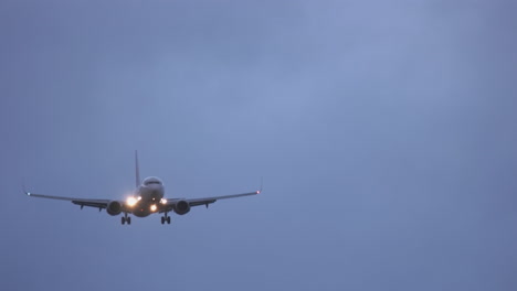 an airliner approaches san diego international airport at dusk in tricky winds.