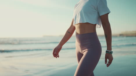 sporty girl with slim body walking and enjoying morning on the beach.