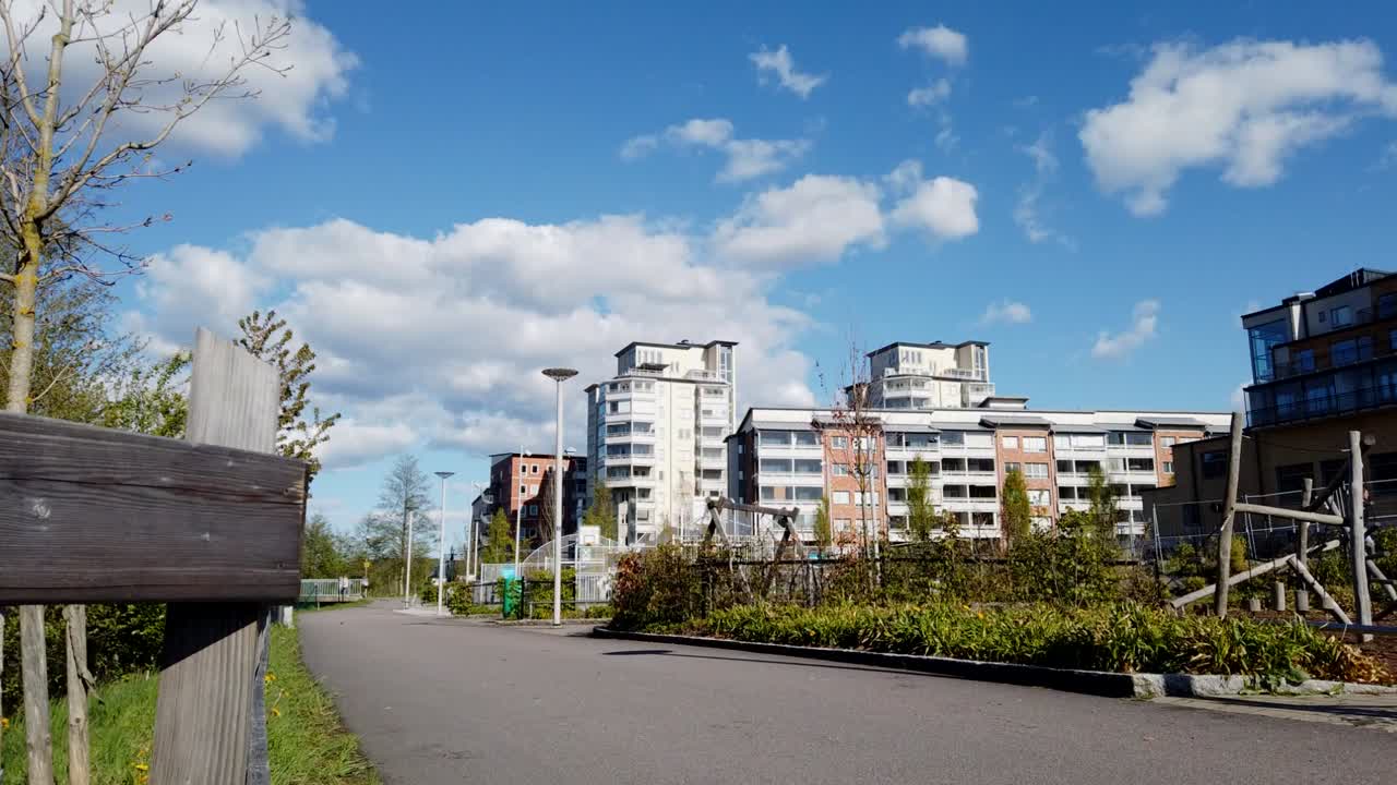 Hyperlapse: low angle view of people, bikes and dogs walking on asphalt urban walkway in Partille, Vastra Gotaland, Sweden
