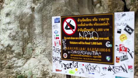 sign with warnings and graffiti in krabi, thailand