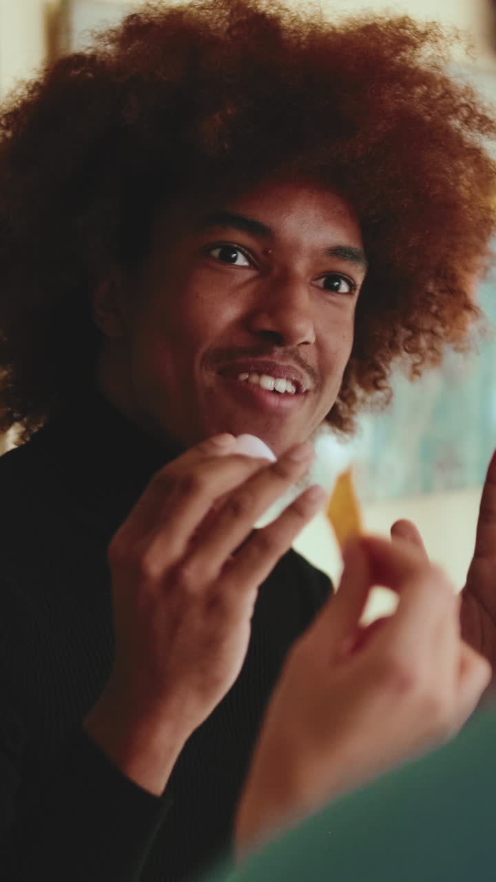 A young adult eating a snack indoors