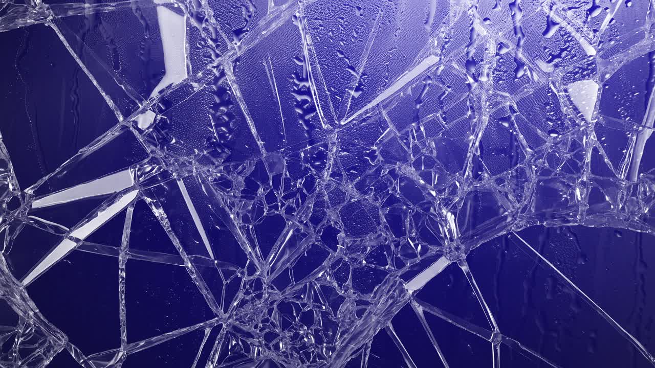 Cracked glass with raindrops and pulsating red and blue police lights. Abstract background for crime, emergency, danger, or urban drama. Dynamic and urgent visual