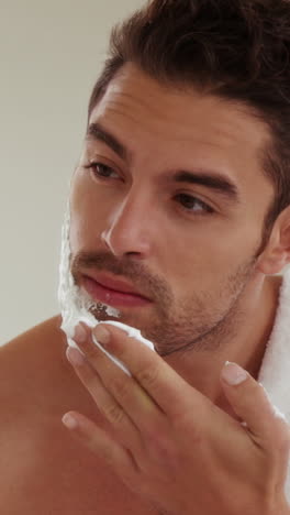 handsome man putting shaving foam on face