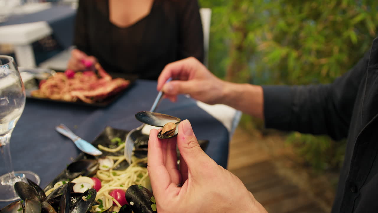 Man Opening A Mussel With Hands And Using The Fork To Eat It