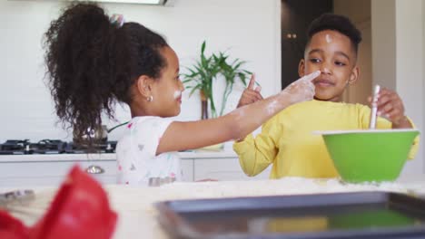 Happy,-messy-african-american-siblings-making-cookies-together-in-kitchen