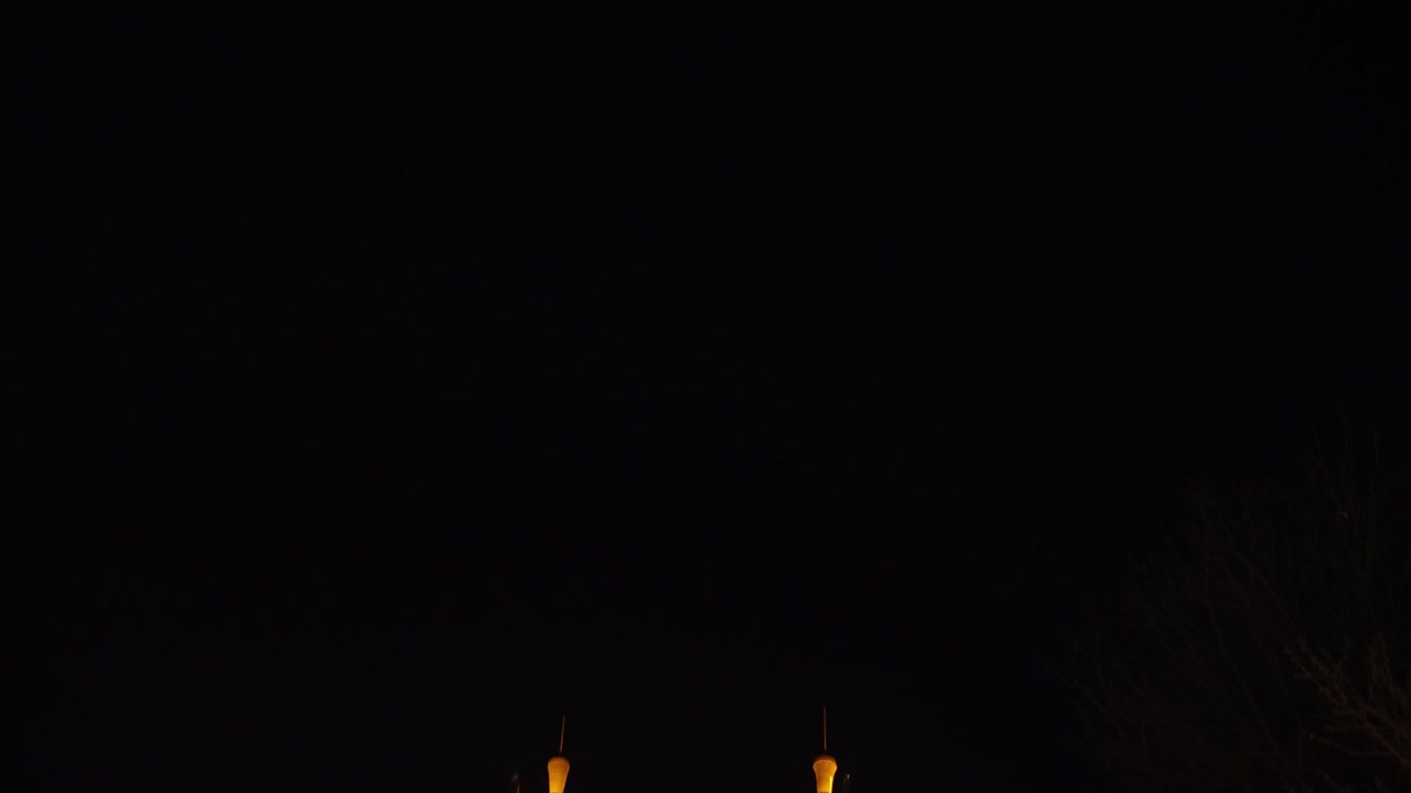 Twin pagoda temples lit up at night along the river in Chengdu