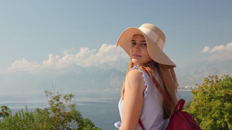 a beautiful young white caucasian female with a hat posing in front of a camera