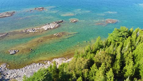Aerial-shot-of-a-river-with-a-rocky-shore-and-trees-on-the-side
