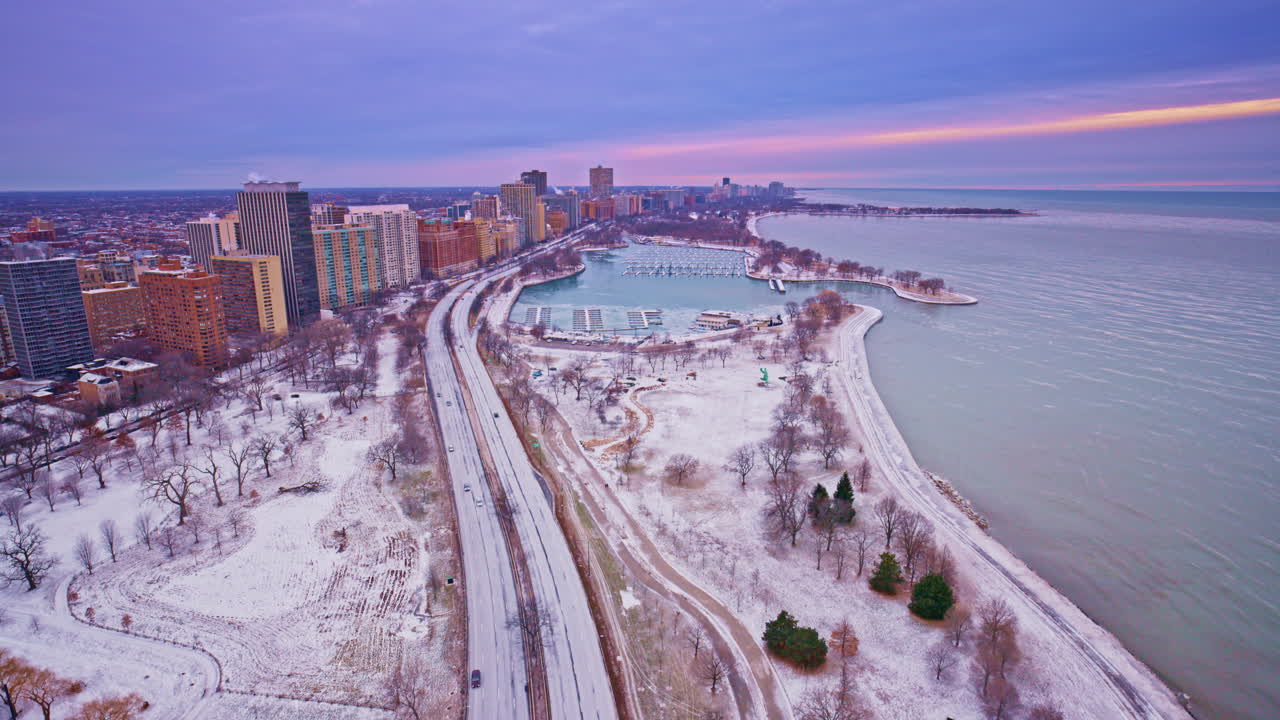 Images de drone spectaculaires capturant le lever du soleil sur le Loop à Chicago, avec la silhouette de la ville et le lac en toile de fond.