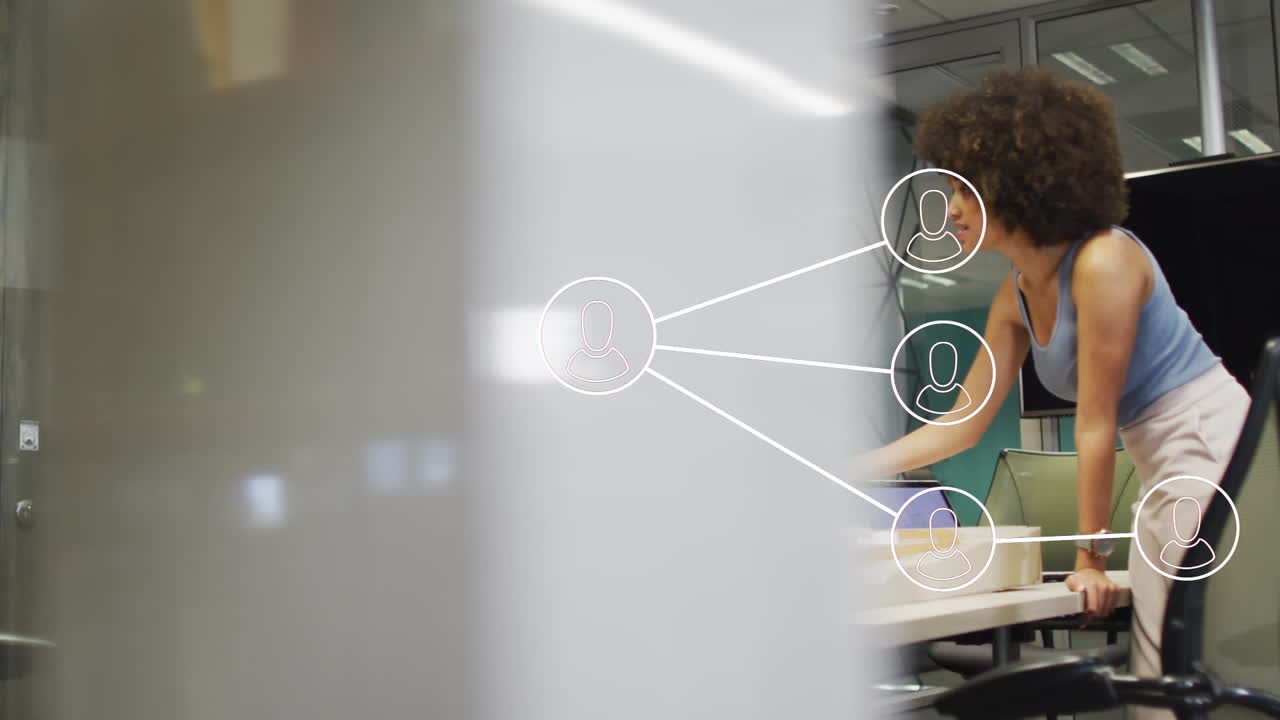 Animation of network of connections with icons over diverse business people working at office