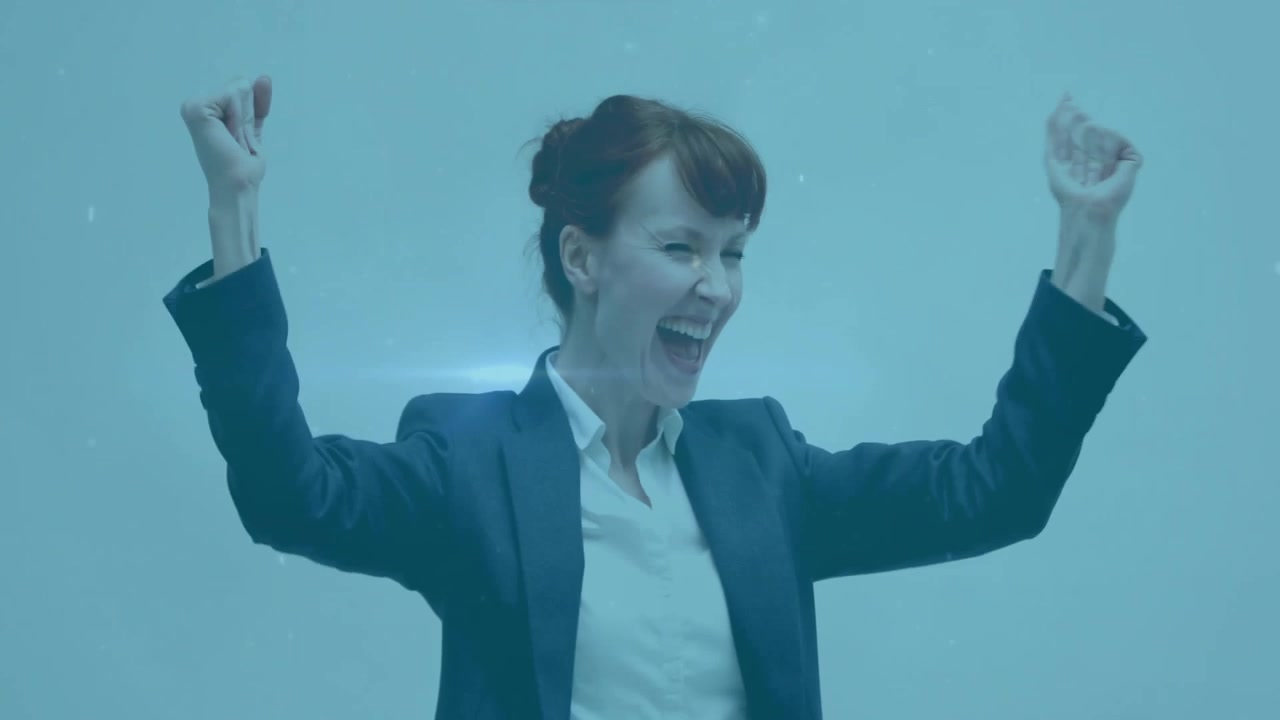Donna d'affari che esulta con un pugno alzato, sorridendo e alzando le braccia, rallegrandosi con scie digitali e particelle che fluttuano
