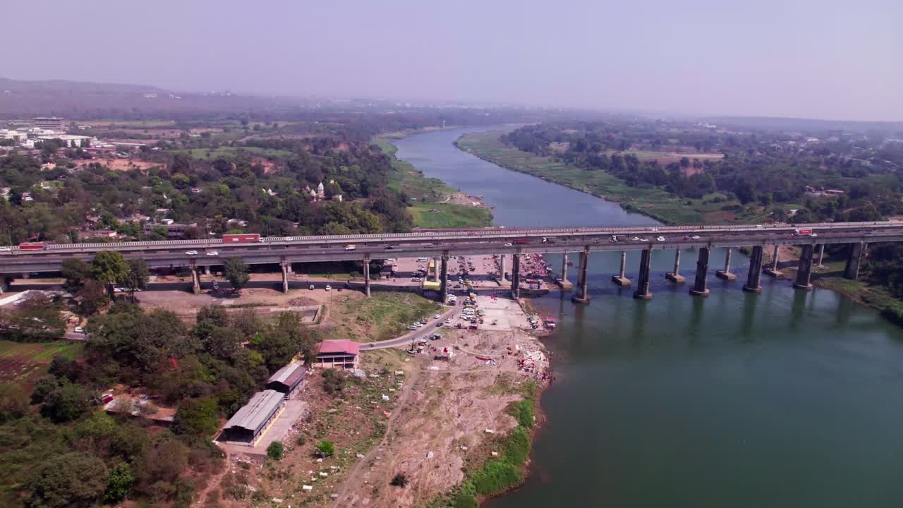 Tilwara Ghat con porto fluviale e ponte sul fiume Narmada, di giorno, in discesa, avvicinamento, ripresa con drone, 4K