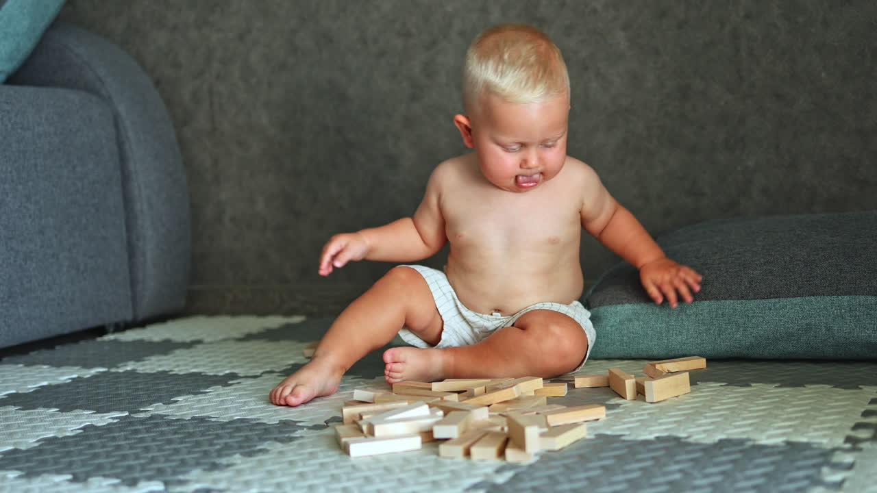 A little boy is playing on the floor at home. The child plays alone at home. Child development