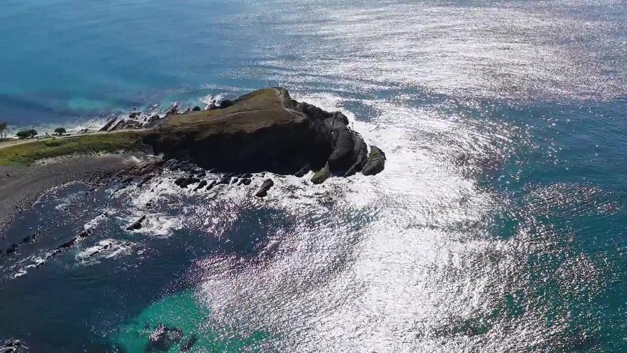 Letecký záběr dronem skalnatého mysu a tyrkysové vody u Crescent Head, Austrálie.