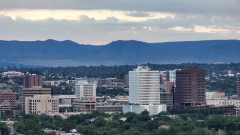 a serene view of albuquerque's skyline during sunrise, with the mountains casting a tranquil backdrop and city buildings standing tall in the foreground