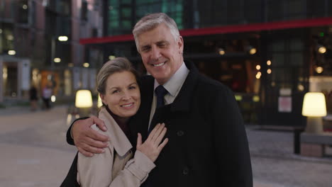 portrait of senior stylish couple meeting in city embracing enjoying urban evening together smiling happy