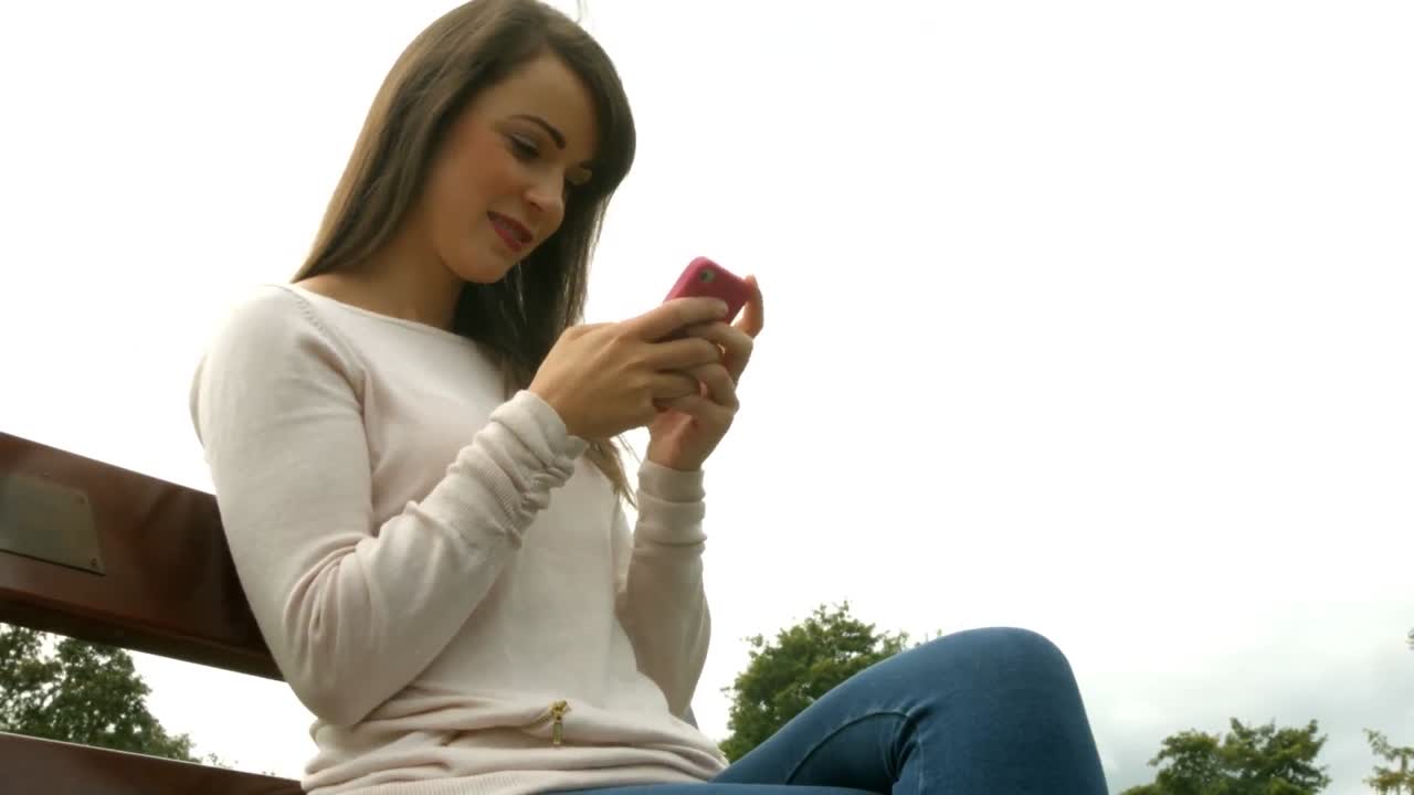 Donna graziosa che per mezzo di uno smartphone