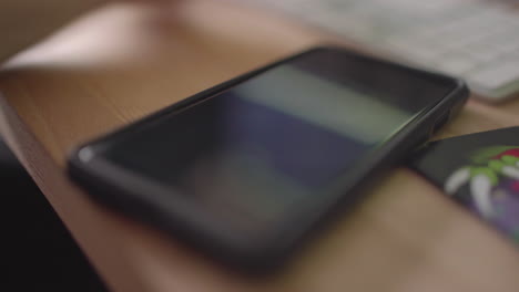 close up on a smart phone being picked up on a desk