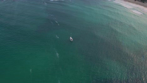 barco de yate navegando en la prístina playa de aguas claras de color azul profundo en la costa de la bahía de la isla de palma de mallorca