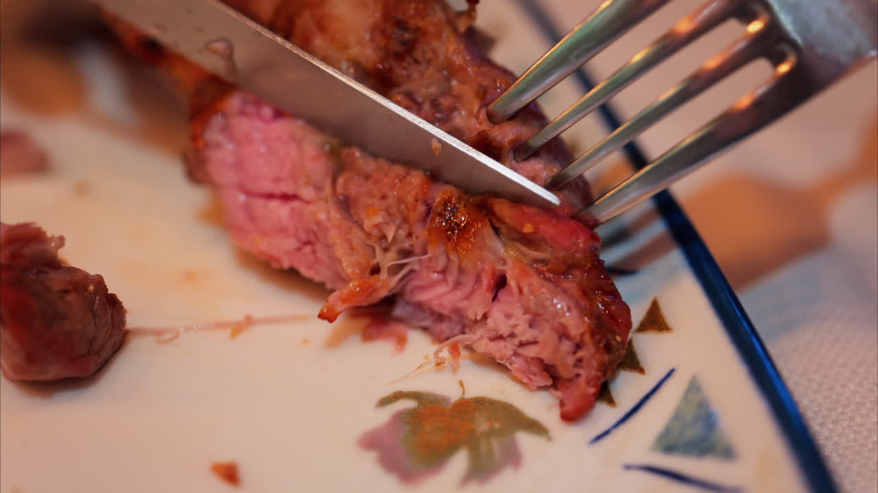 Close up of lamb chops being cut on a plate at a restaurant