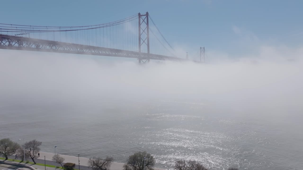 Drone shot of the bridge (25 Abril), in the fog in Lisbon.