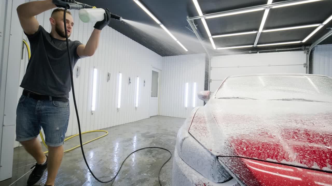 Red car wash with flowing water and foam.