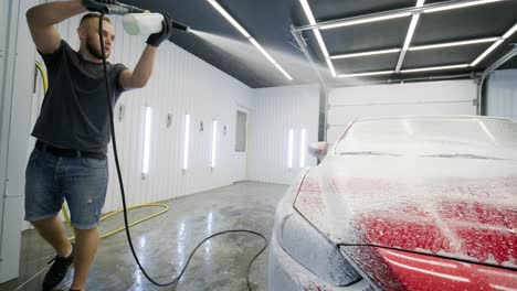 red car wash with flowing water and foam.