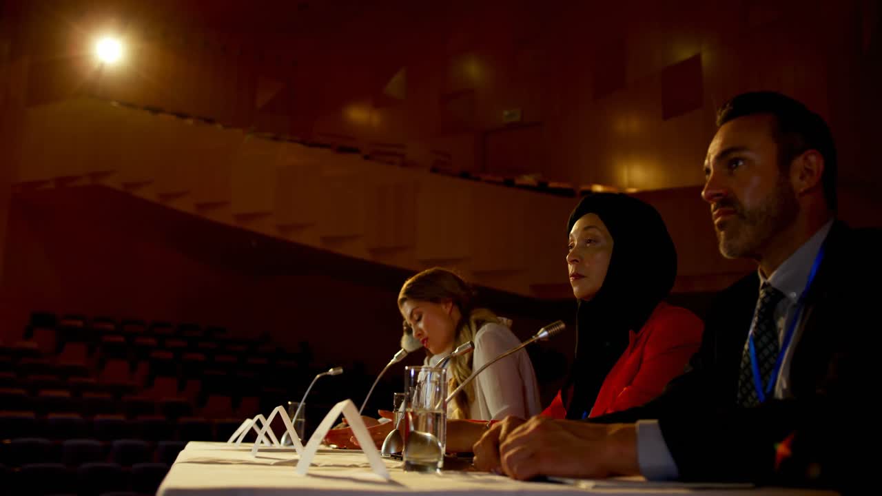 Bella giovane donna d'affari caucasica parla a un seminario aziendale in un auditorium 4k