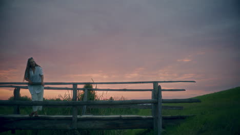 pensive woman on a wodden bridge dusk