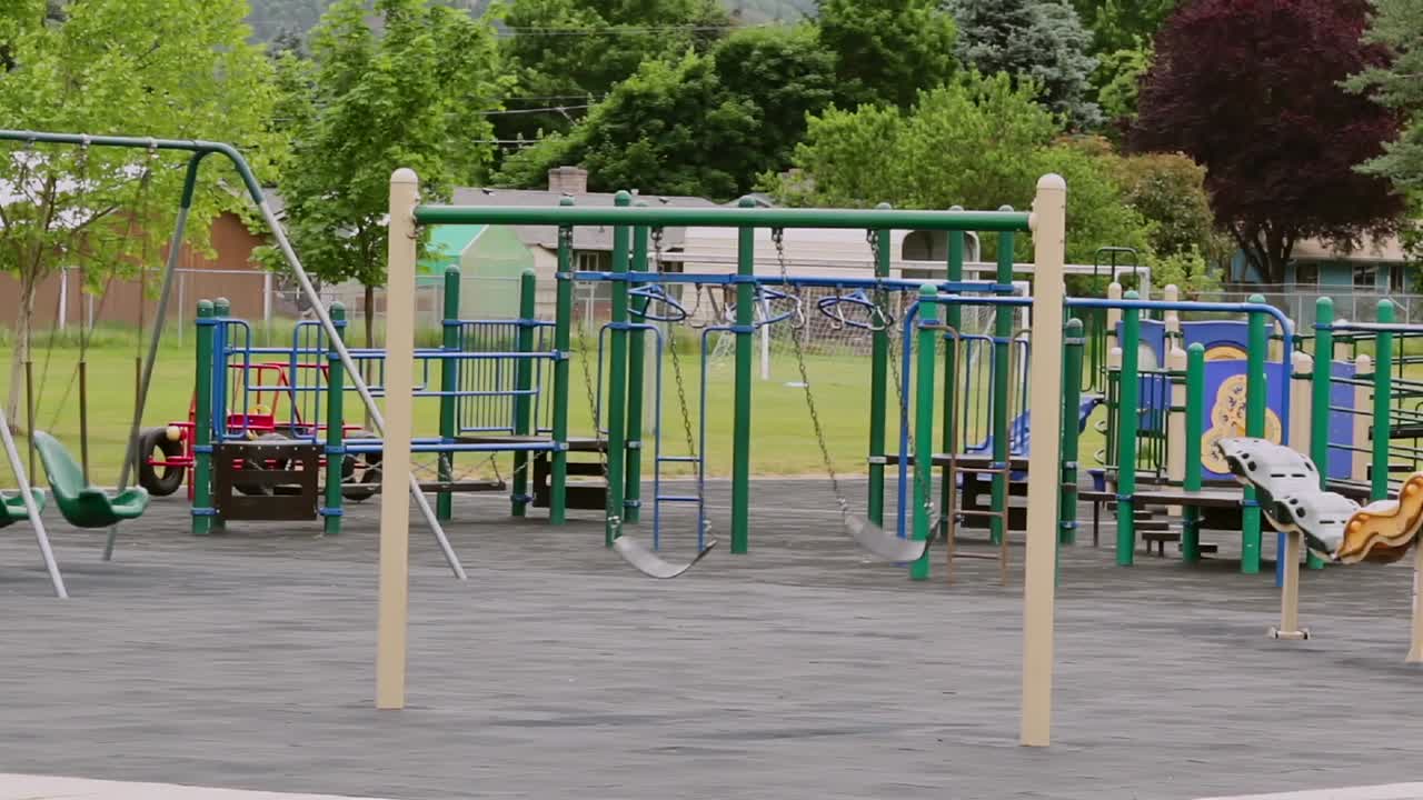 parque escolar vacío de la ciudad con columpios meciéndose con el viento por sí solos, sin gente