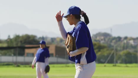 disappointed caucasian female baseball player holding head, crouching on field after losing a game