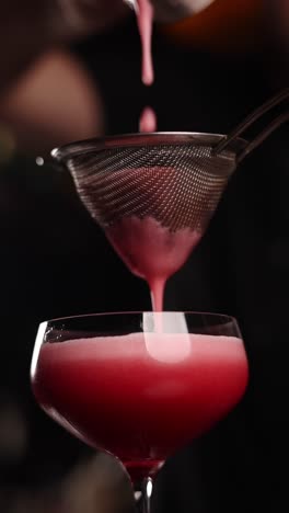 bartender preparing a red cocktail