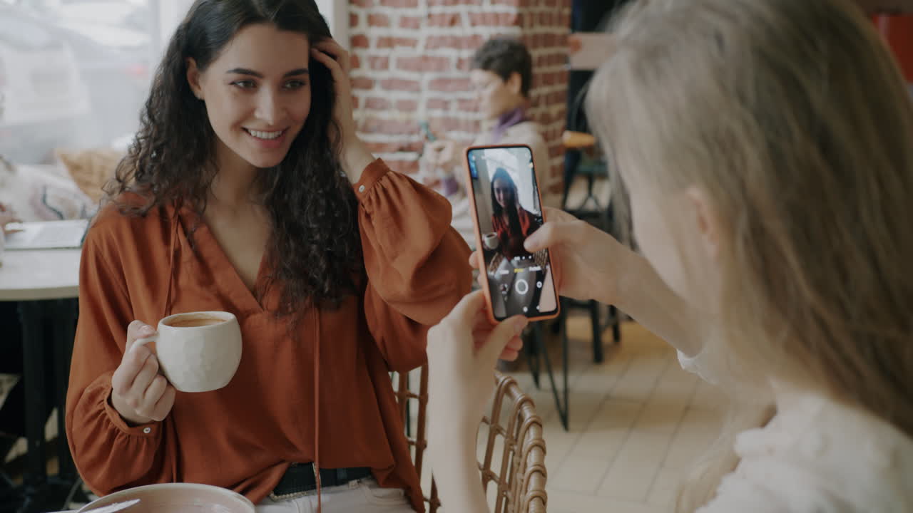 Two women taking a selfie in a cafe