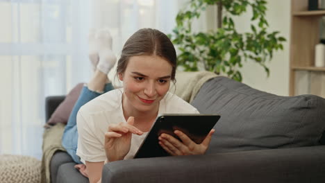 mujer relajándose en el sofá con la tableta