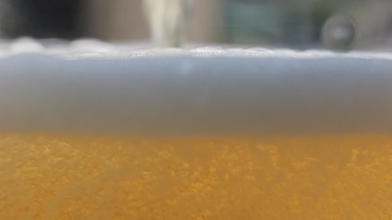 Macro beer pouring with bubbles and head foam