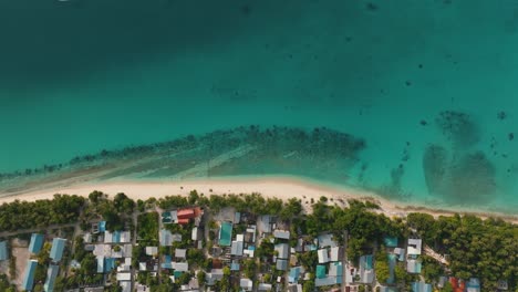 Una-Toma-Aérea-Del-Paisaje-De-Un-Pueblo-Costero-Y-Un-Vecindario-Estrecho-Con-árboles