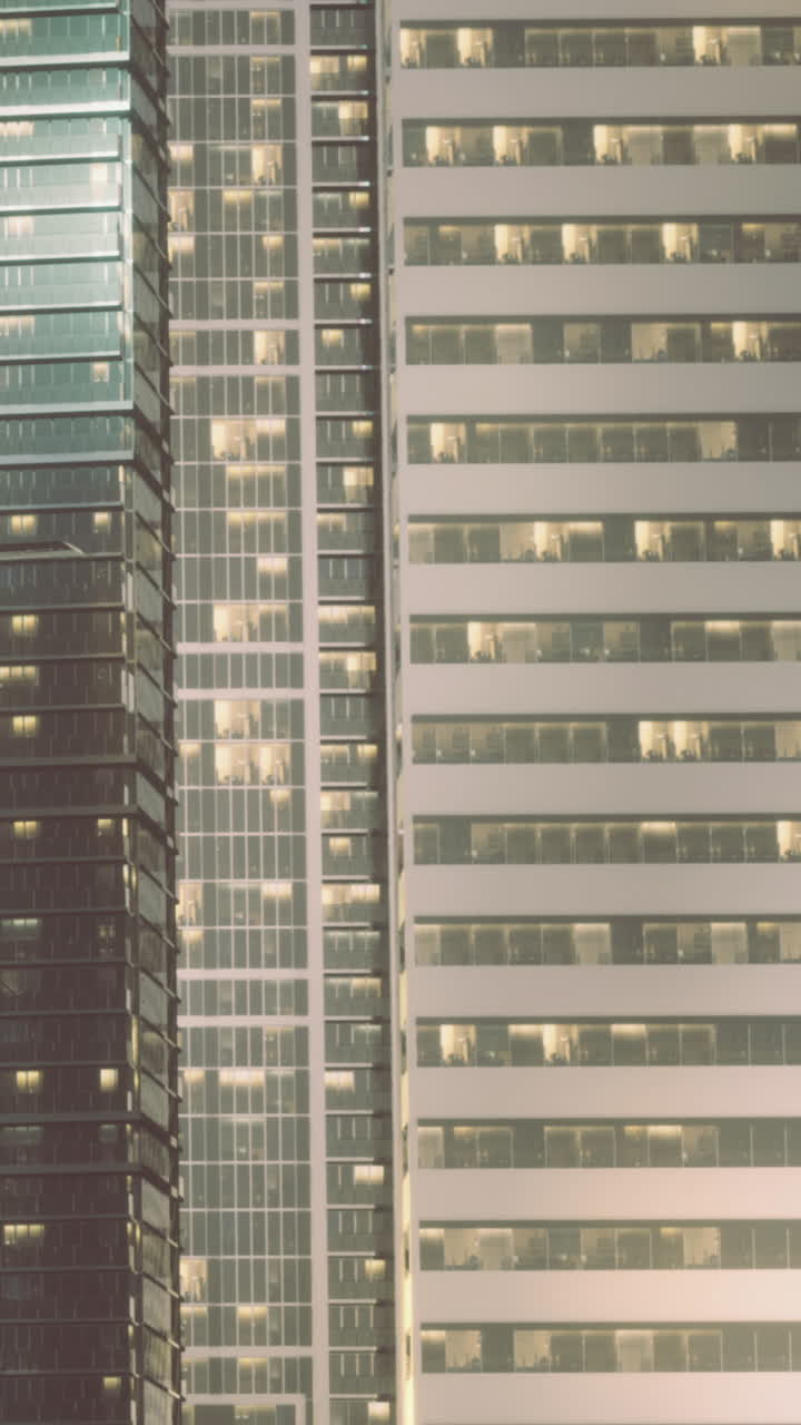 Edificios de la ciudad de noche con ventanas iluminadas en la zona céntrica.