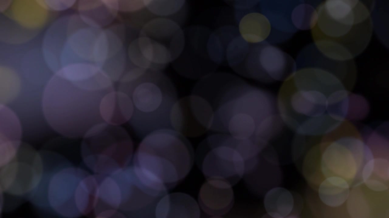 Luci Bokeh Colorate Fluttuanti su uno Sfondo Scuro.