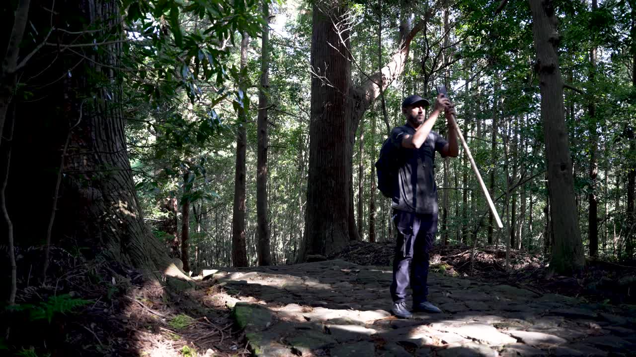 Hiker exploring Kumano Forest walking along the ancient Kumano Kodo pilgrimage route in Japan