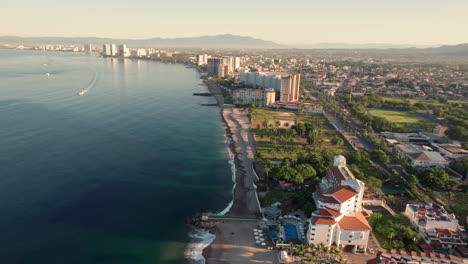 Drone-video-capturing-the-coast-of-Puerto-Vallarta-from-a-great-height,-featuring-the-hotel-zone-and-the-sea,-showcasing-the-vast-size-of-Banderas-Bay