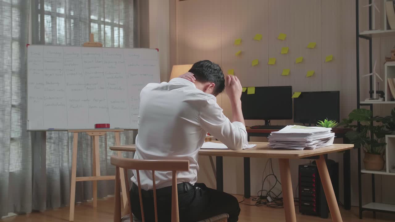 사무실 에서 문서 를 가지고 열심히 일 한 후 스트레칭 하는 아시아인 의 뒷면