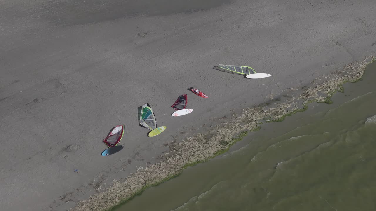 Windsurf boards on shore of Makkum beach during summer, aerial